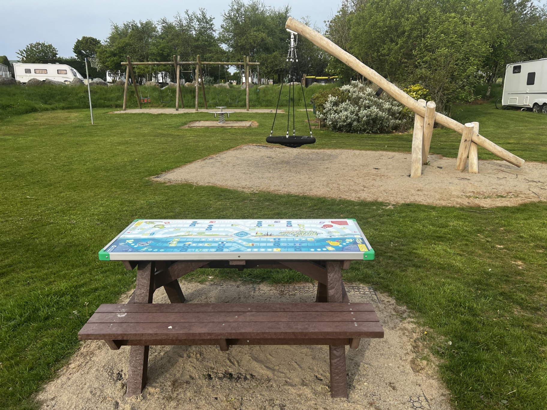 Nest swing and game-top picnic table in the Pen Parc play area