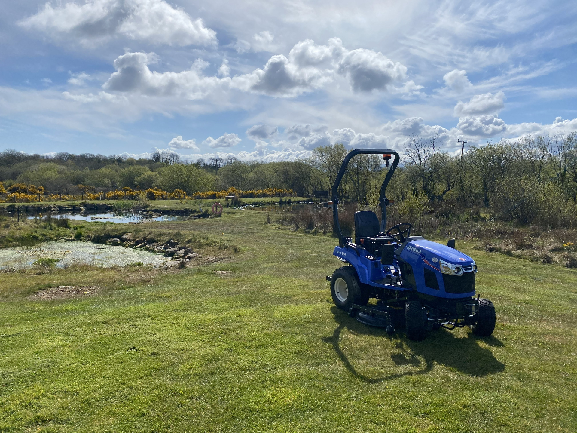 Tractor parked by the pond on a spring day